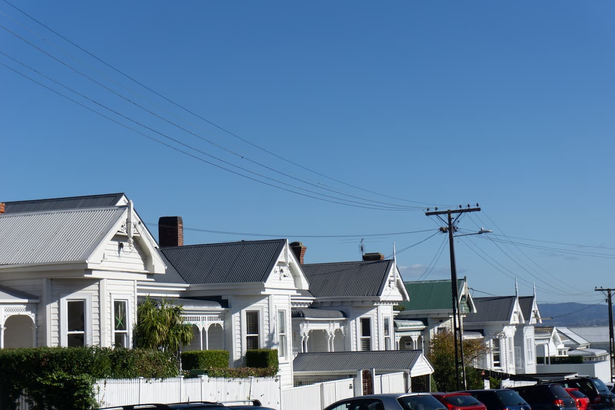 A row of classic white villa rental properties under a blue sky, representing property depreciation and landlords who want to stop overpaying tax on their rental.